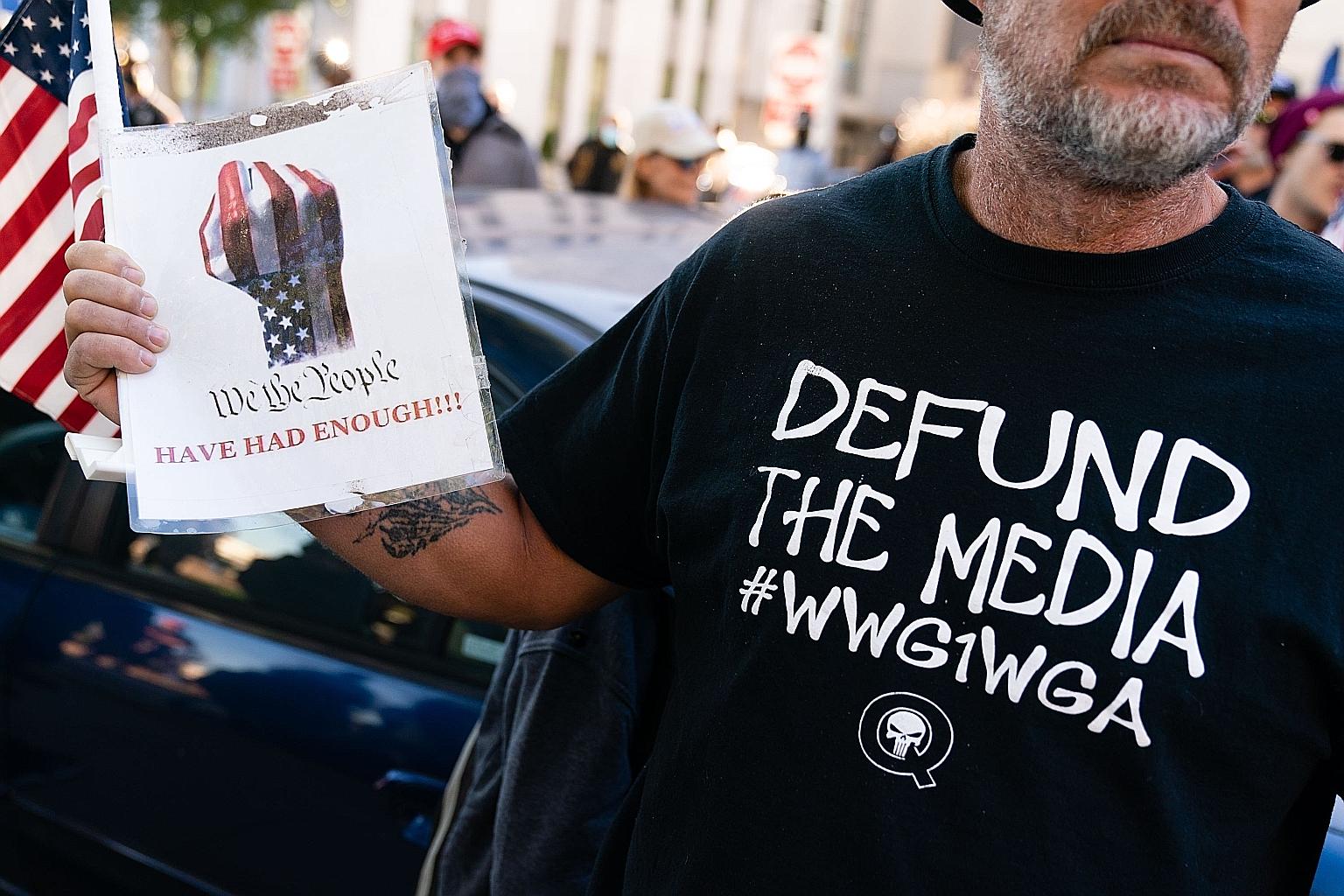 A QAnon conspiracy theory supporter wearing a "Defund the media" QAnon shirt at a "Stop the steal" rally against the results of the US presidential election outside Georgia's state capitol in Atlanta on Nov 18 last year.