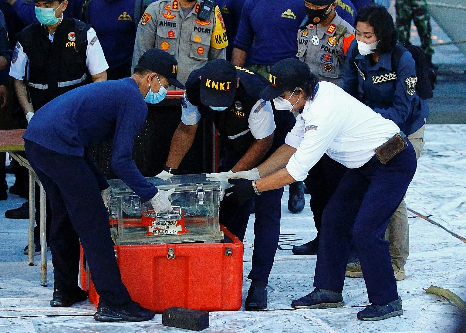 Indonesian National Transportation Safety Committee officials handling part of the recovered flight data recorder, which contains key data like airspeed and altitude, in Jakarta yesterday. PHOTO: REUTERS