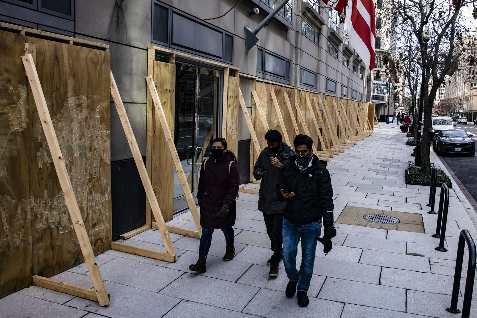 Pedestrians walking past a boarded-up office building in Washington on Jan 2. Many buildings in the city of more than 700,000 have been boarded up due to pandemic closures or riots. Troop deployment has also been increased in the lead-up to Mr Joe Bi