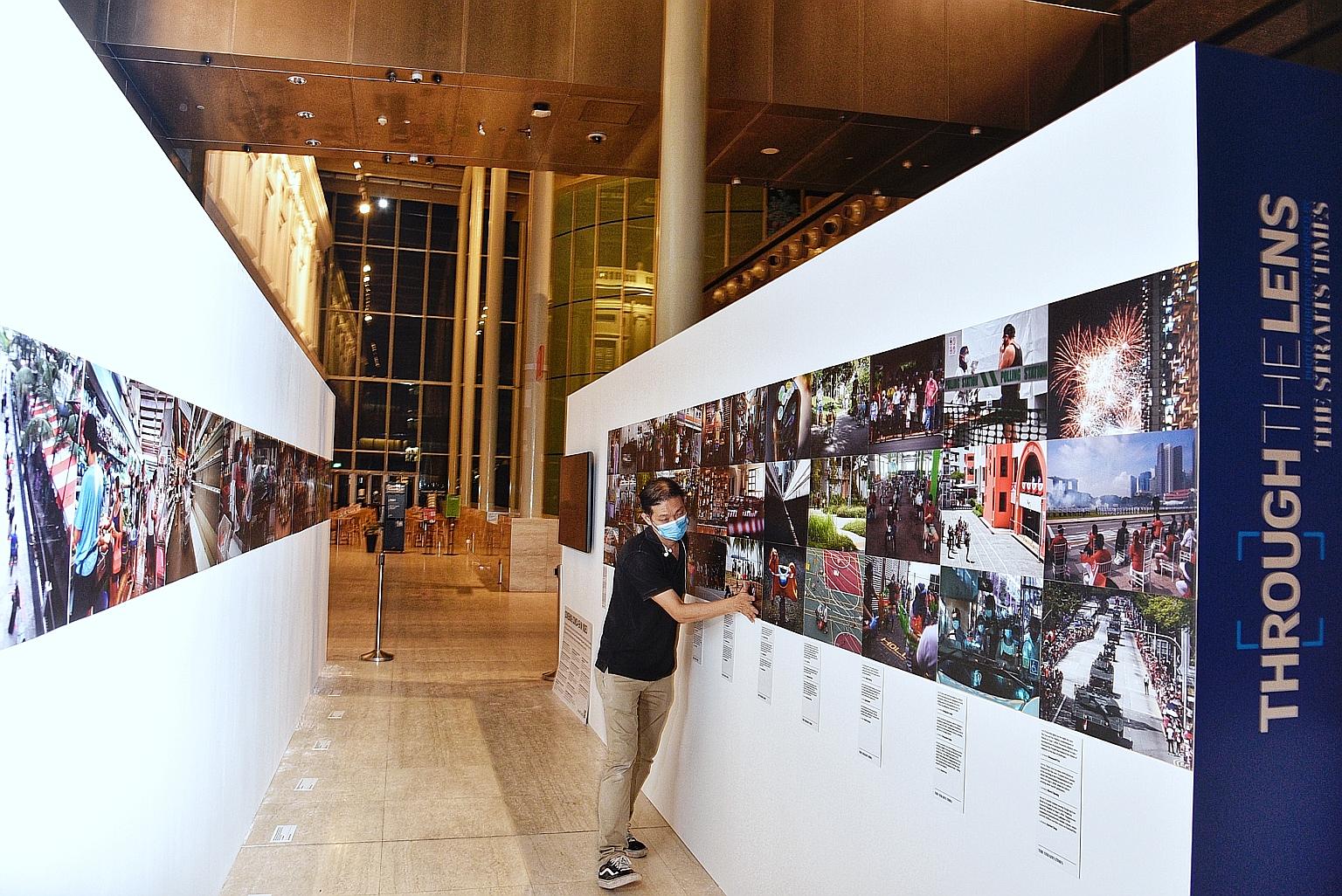 An employee setting up an exhibit last night at Through The Lens, a photography exhibition by The Straits Times and World Press Photo (WPP). It will feature ST photojournalists' coverage of the Covid-19 pandemic here, as well as photos submitted for