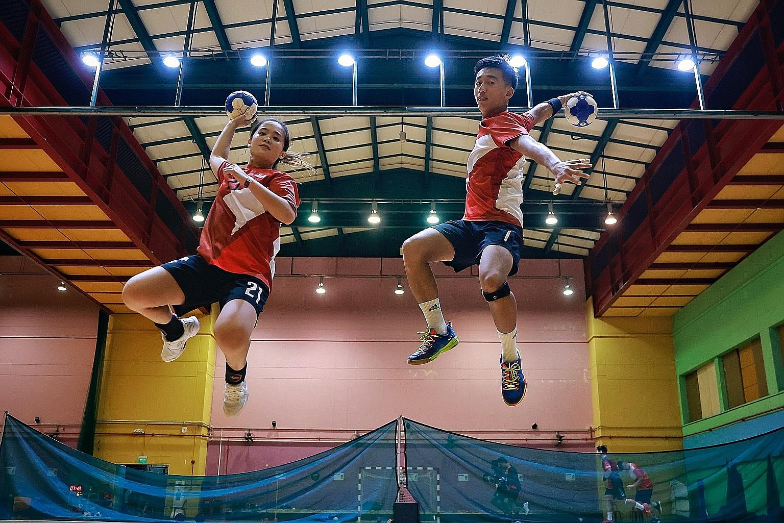 National handballer Ham Jia Yun, 30, and men's captain Teo Kee Chong, 25, showing skill and agility in shooting during training. They have been playing the sport for about 10 years.