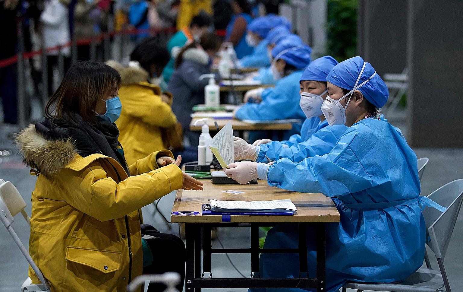 Medical workers registering people for Covid-19 vaccination in Beijing yesterday. Thousands of vaccination centres have been set up across the country, and more than a million people have been inoculated in the Chinese capital alone.