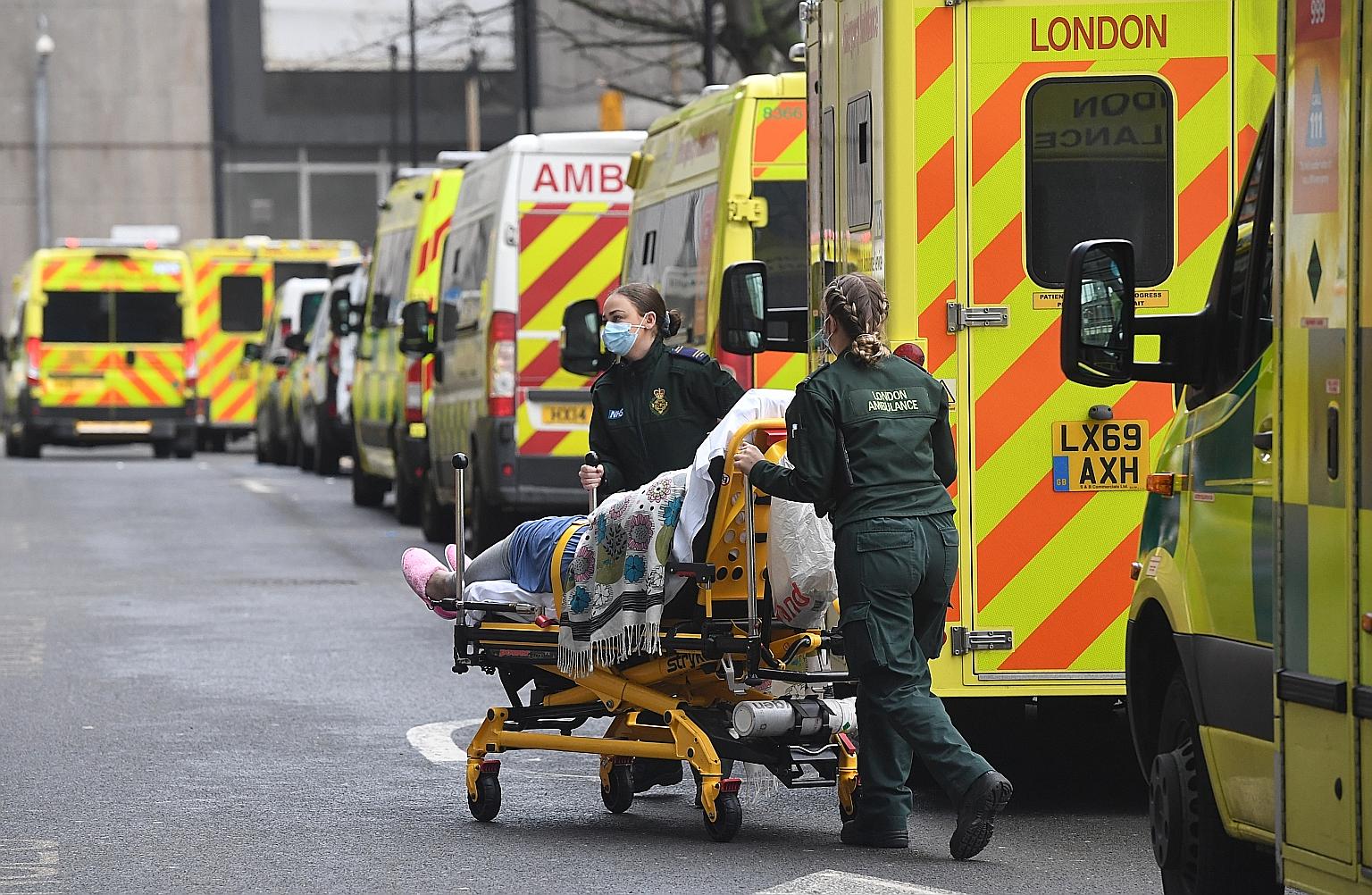 Paramedics transporting a patient outside the Royal London Hospital in Britain on Friday. The stricter rules come as hospitalisations and deaths continued to soar, taking the mortality toll to 87,295, the highest in Europe.