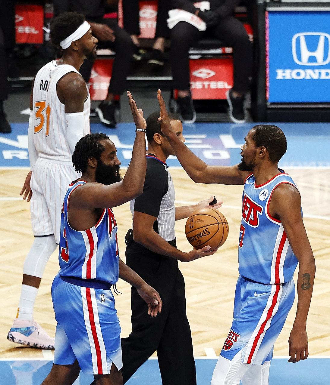 Nets forward Kevin Durant high-fives new teammate James Harden in their 122-115 home win over the Magic on Saturday. Former Rockets guard Harden became the seventh NBA player to score a triple-double (32 points, 12 rebounds, 14 assists) on his debut 