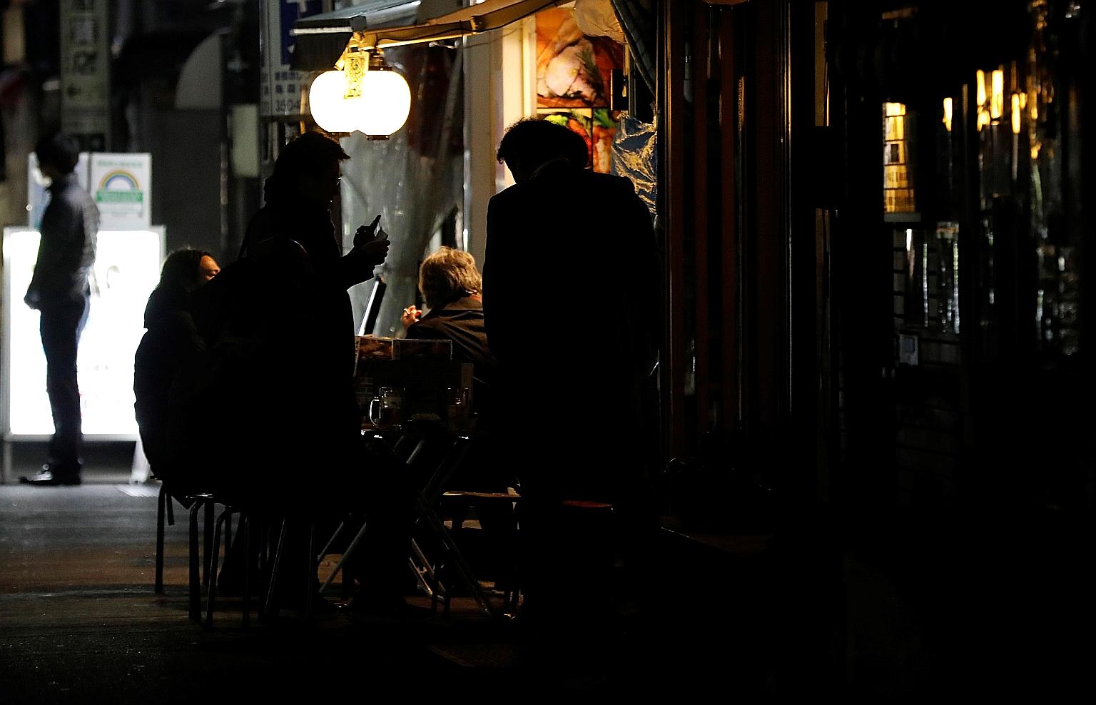 People drinking outside a bar in Tokyo last Friday past the 8pm cut-off time. While compliance has been high, more people appear to be ignoring this state of emergency than the one last year. The government has offered subsidies to establishments tha