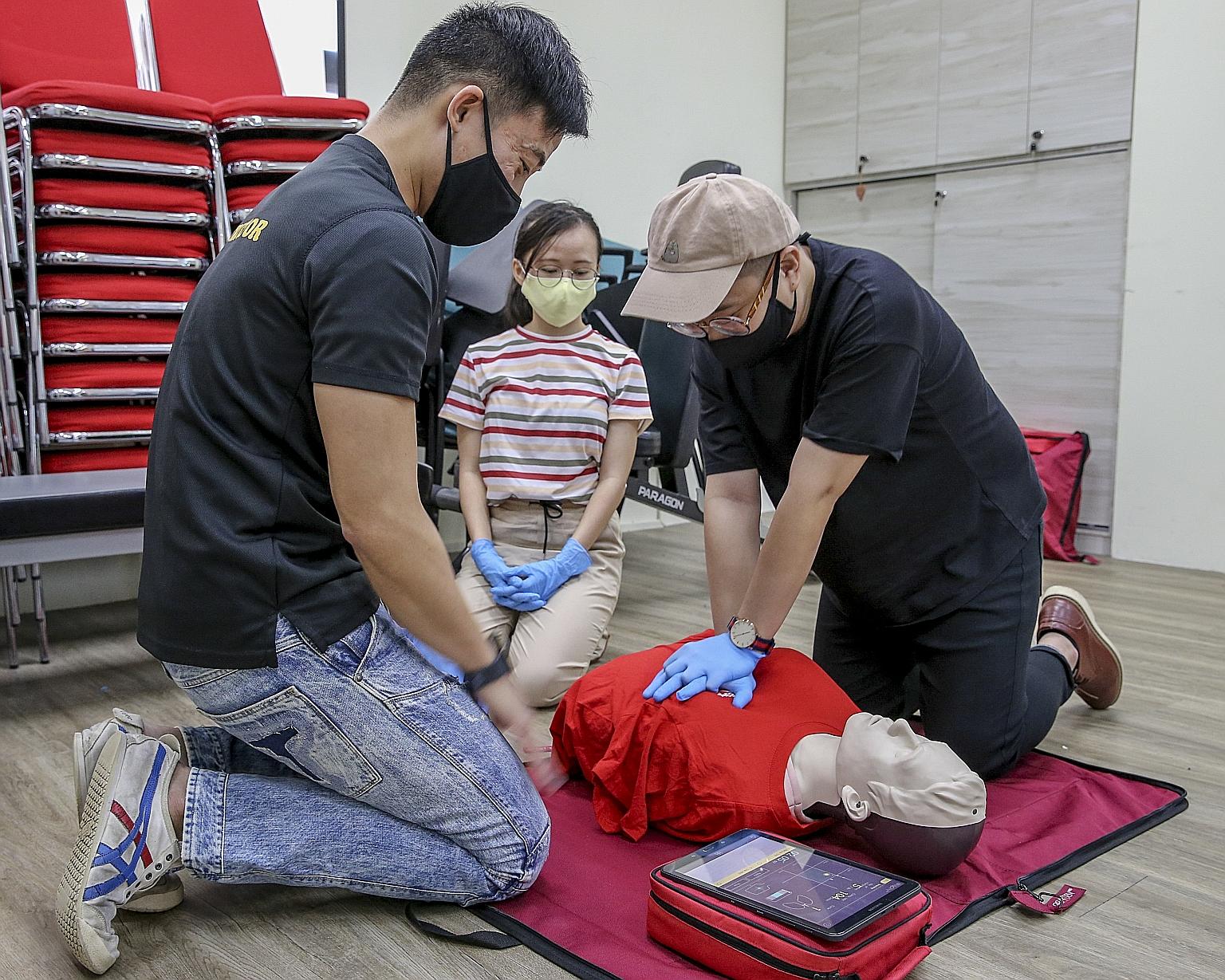 People learning how to administer cardiopulmonary resuscitation (CPR) using the new female manikin vest at the Singapore Heart Foundation last Friday. Traditionally, CPR training is taught with manikins with a male physique. The manikin vests were di