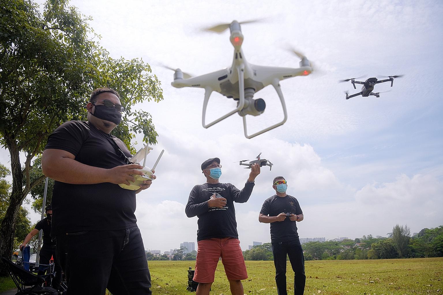 People flying their drones at an open field in Old Holland Road. An unmanned aircraft systems advisory panel said in its report that the setting up of common drone-flying spaces will enable recreational drone users to gather and "foster a culture of