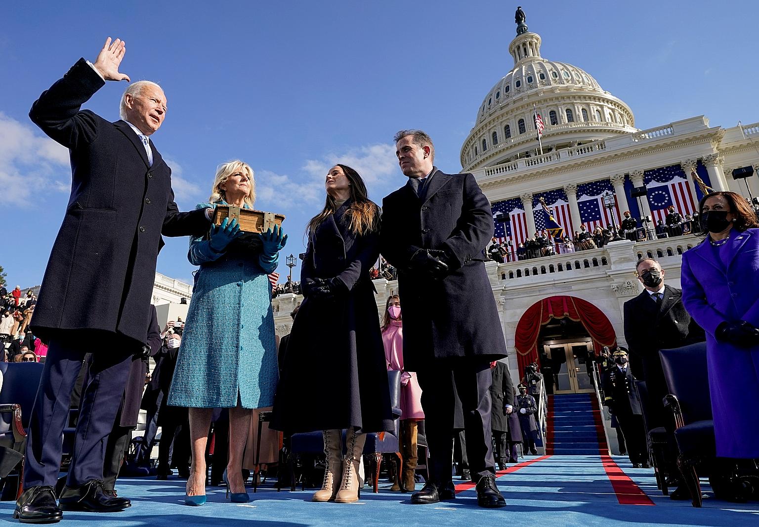 Mr Joe Biden being sworn in as the 46th US President yesterday at the Capitol, with his wife Jill Biden holding the Bible. Beside them are their daughter Ashley and son Hunter, Vice-President Kamala Harris (right) and her husband Douglas Emhoff (behi