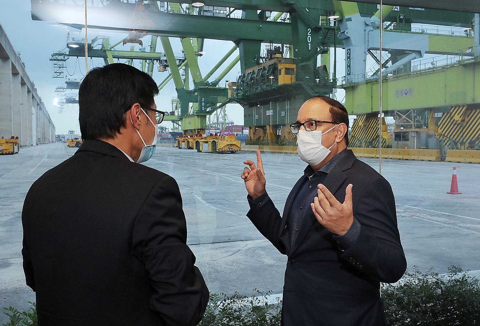 Minister S. Iswaran and Head of Tuas Development Nelson Quek (left) at the demonstration of the automated guided vehicle yesterday. ST PHOTO: GAVIN FOO