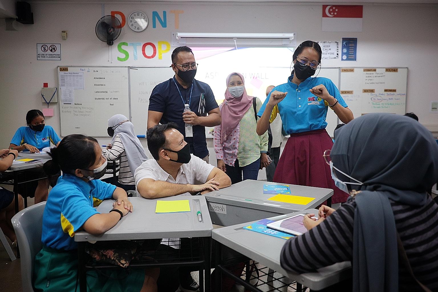 Mendaki student Nisha Maria Isabella Mohd Faisal demonstrating a dance before (seated, from left) fellow student Nurinsyirah Muhd Herman, Mendaki deputy chairman Zaqy Mohamad and Mendaki mentor Nur Syahzanani Suhaizan at Unity Secondary School on Wed