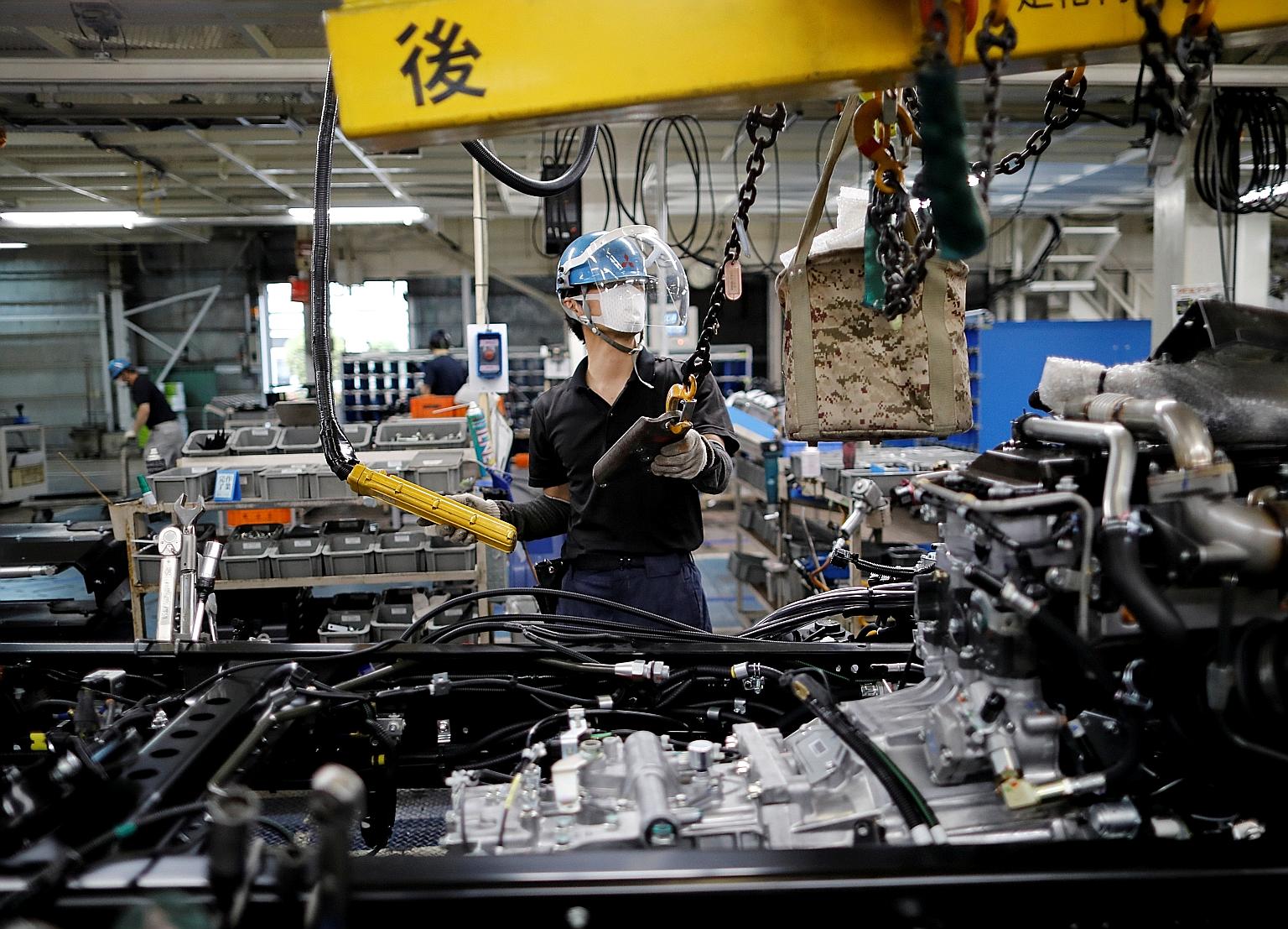 An employee at Mitsubishi Fuso Truck and Bus Corporation's factory in Kawasaki, south of Tokyo, last May. The au Jibun Bank Flash Japan Manufacturing PMI fell to 49.7 this month from a final 50.0 last month, largely due to weakening output and new ex