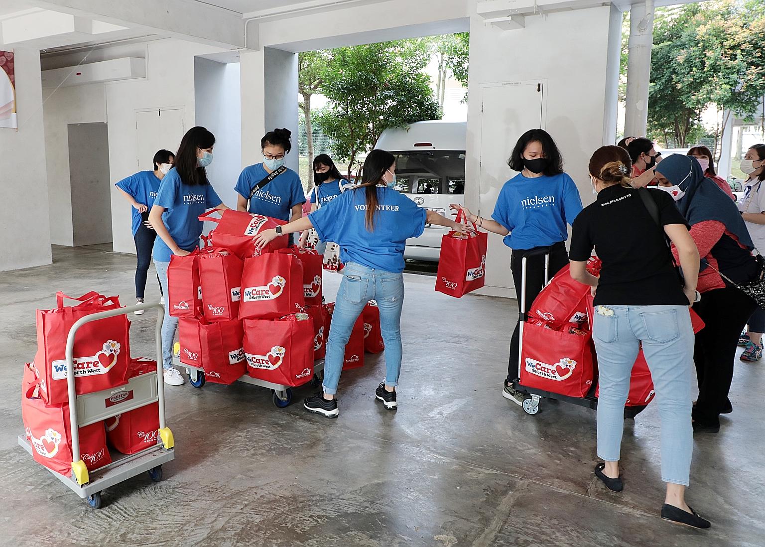 Volunteers yesterday preparing to send out festive packs containing food items such as soya milk powder, instant noodles, coffee, sunflower oil and oatmeal to residents living in rental units in the North West District. PHOTO: LIANHE ZAOBAO