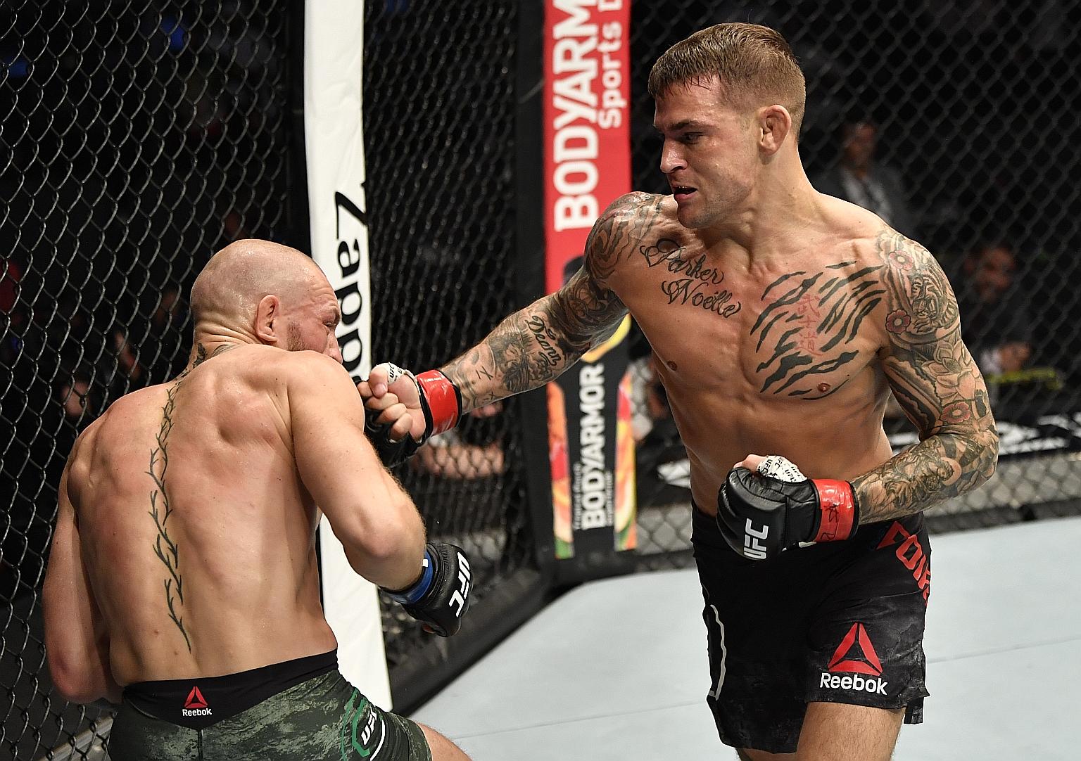 American MMA fighter Dustin Poirier punching Ireland's Conor McGregor during their lightweight fight at UFC 257 in Abu Dhabi. Poirier knocked his rival out in the second round to avenge his 2014 TKO defeat.