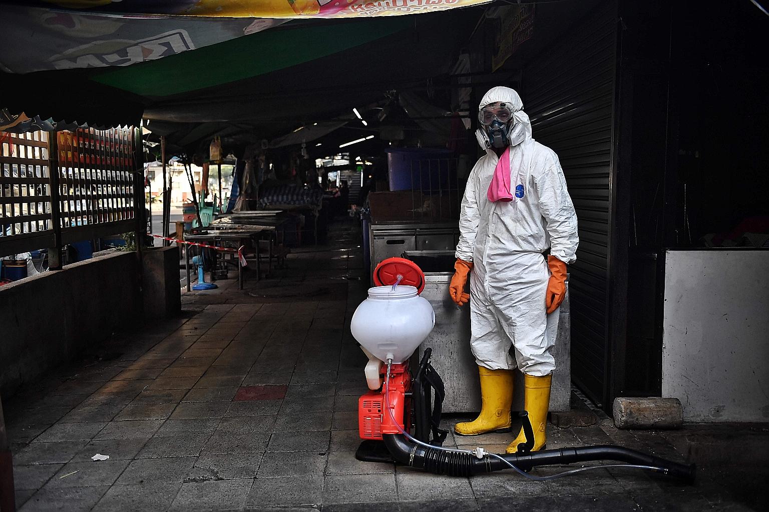 A man preparing to spray disinfectant around Klong Toey fresh market, after it was temporarily shut down due to several vendors testing positive for Covid-19, in Bangkok on Jan 14.