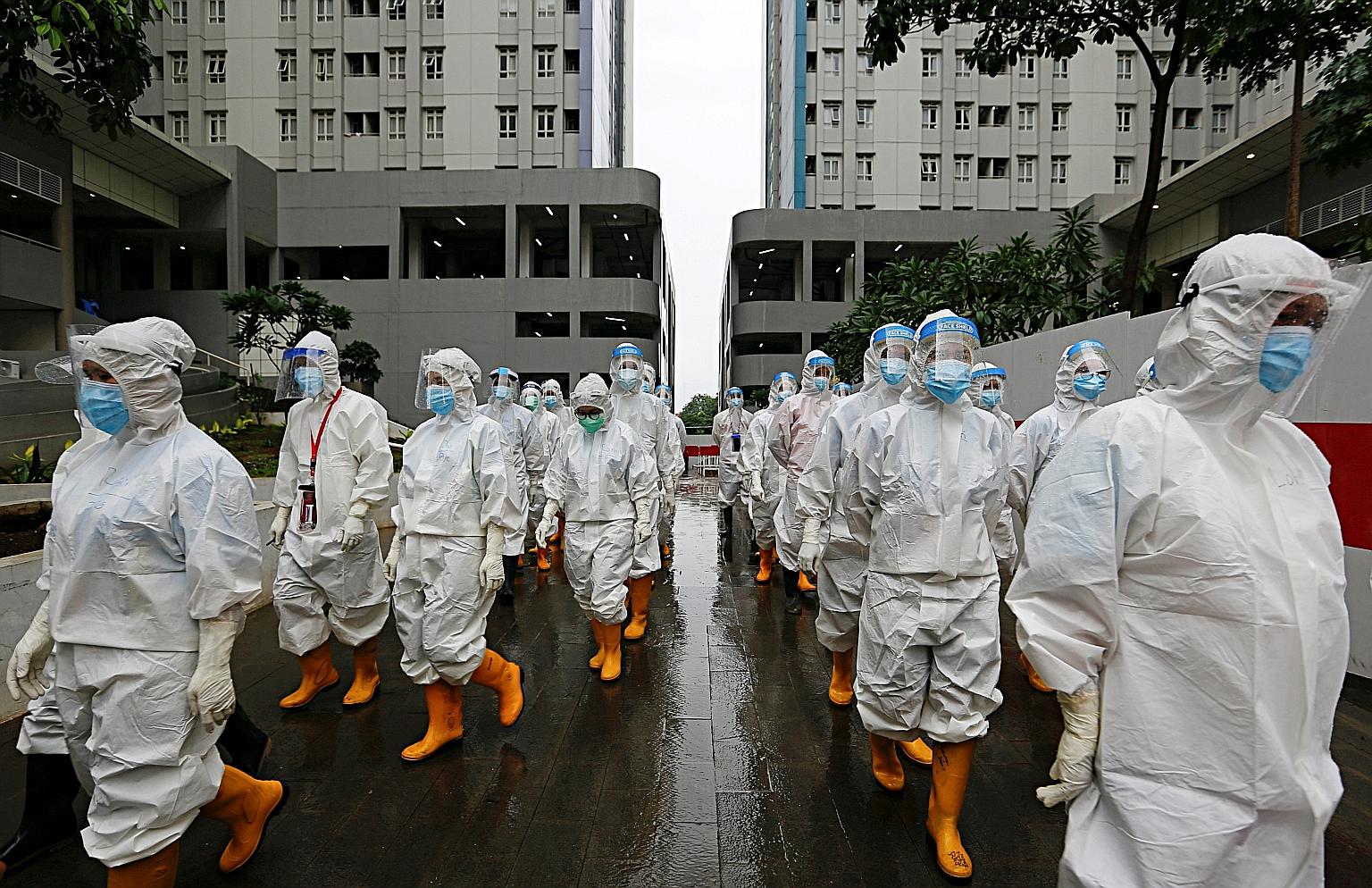 Healthcare workers wearing personal protective equipment preparing to treat patients at the athletes' village converted into an emergency hospital for Covid-19 in Jakarta on Tuesday. PHOTO: REUTERS