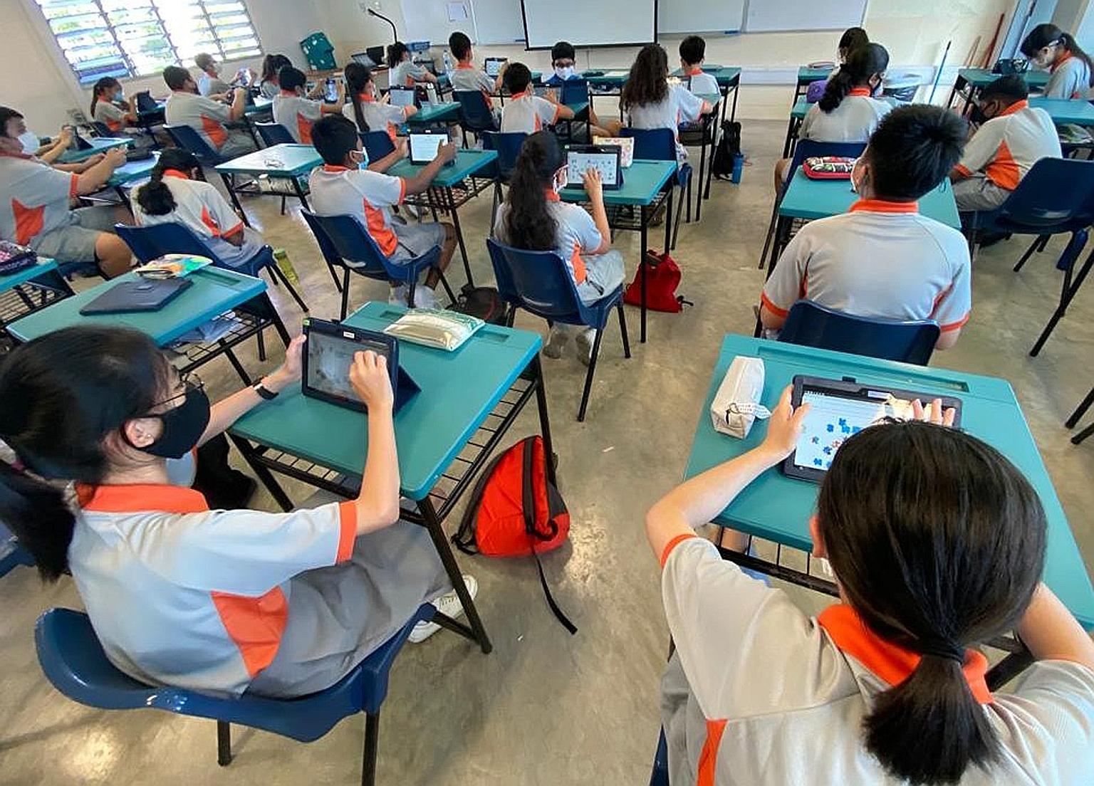 Teck Whye Secondary students using personal learning devices in this file photo. The software lets schools manage students' usage of tablets or laptops that support home-based learning. PHOTO: TECK WHYE SECONDARY SCHOOL