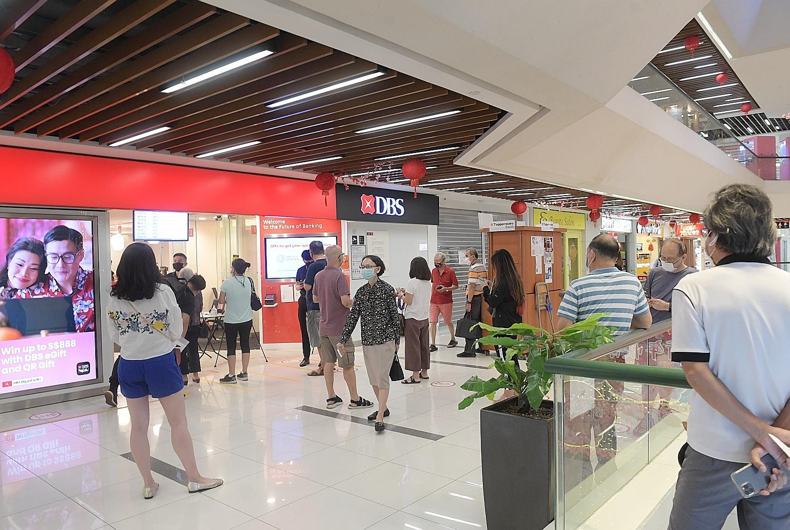 People waiting outside the DBS Bank branch at Bukit Timah Plaza on Tuesday at around 10am. There has been high demand for online reservation slots to exchange old notes for new ones in recent days, with customers complaining about long queues at bran