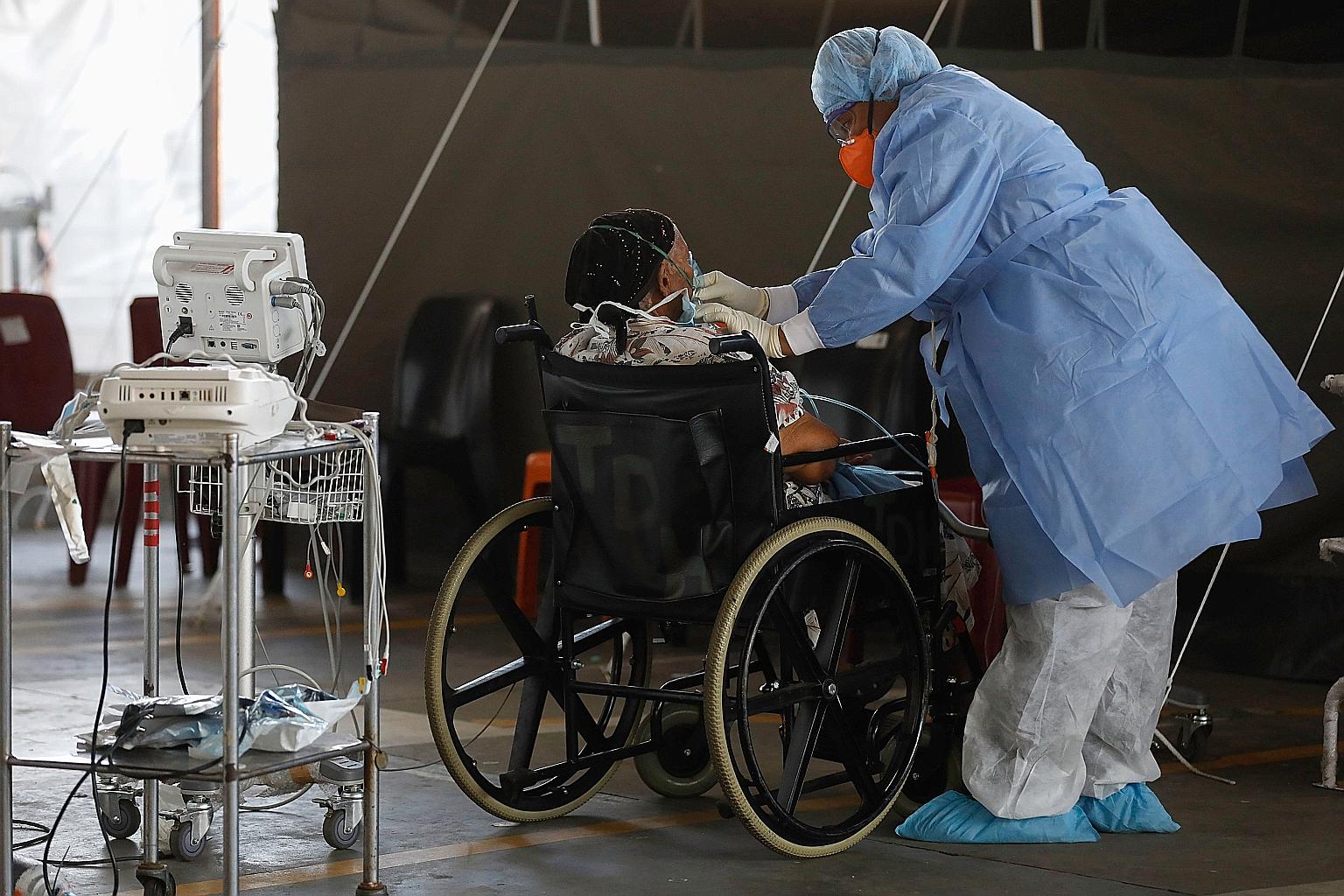 A healthcare worker attending to a patient at a temporary ward dedicated to Covid-19 cases in Pretoria, South Africa, earlier this month. PHOTO: AGENCE FRANCE-PRESSE