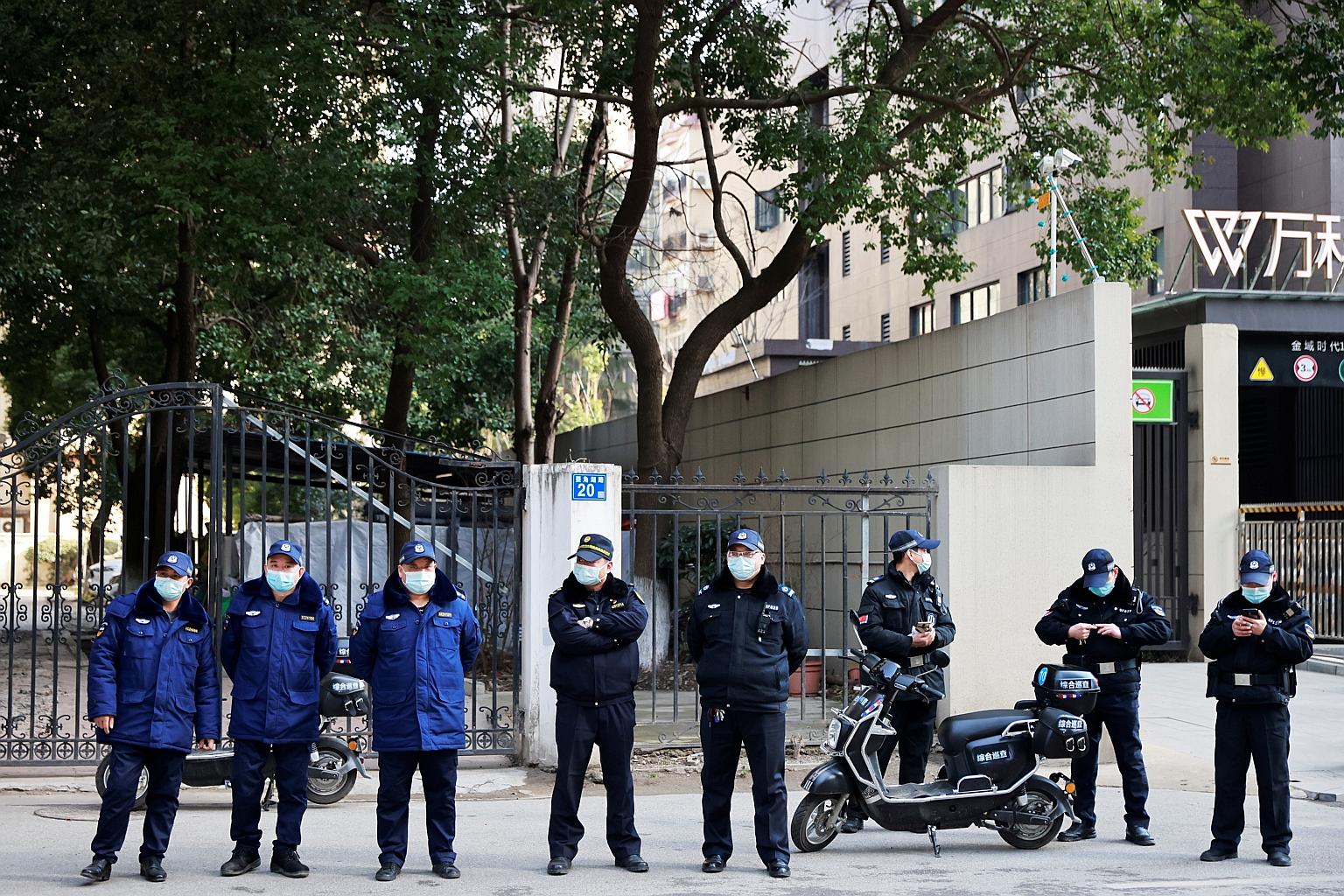 Police officers keeping watch outside the Hubei Provincial Hospital of Integrated Chinese and Western Medicine in Wuhan yesterday during a visit by the World Health Organisation-led team of experts investigating the origins of Covid-19. The director