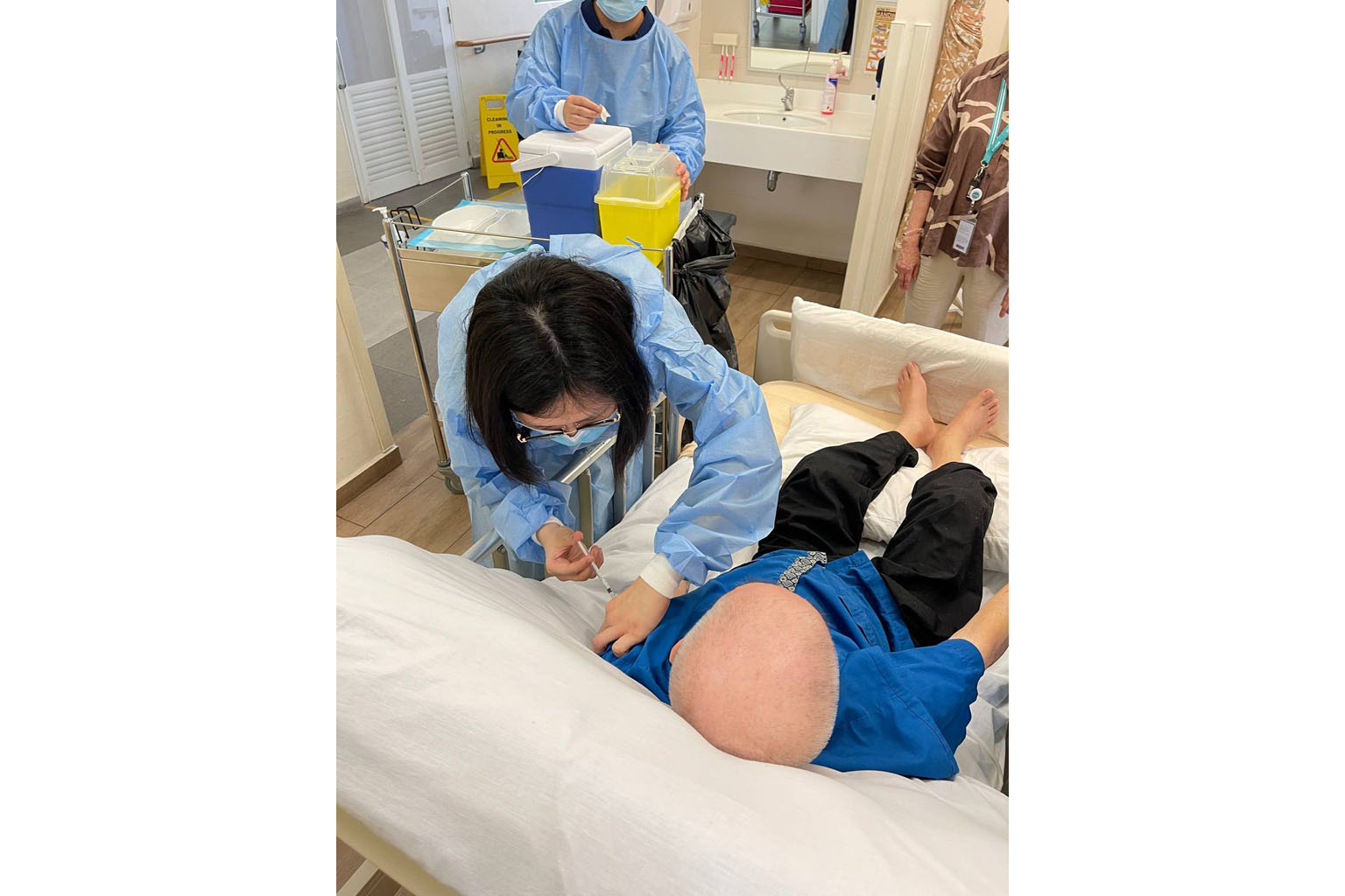 A staff member at NTUC Health's nursing home in Chai Chee vaccinating a resident on Monday. Vaccinated residents are monitored closely for 30 minutes after receiving the jab, with nurses looking out for signs of allergic reactions. Half the pool of e