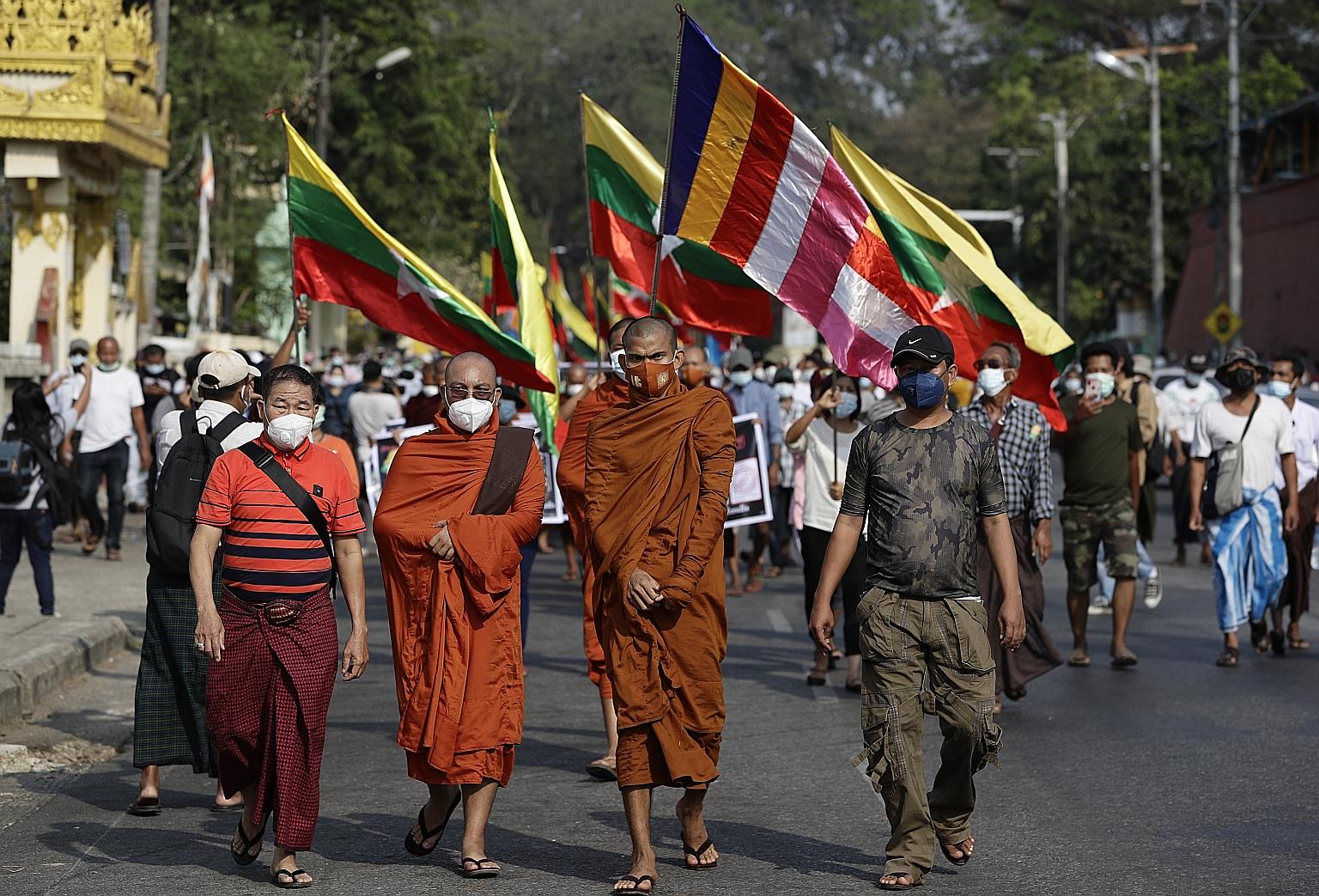 Buddhist monks and military supporters holding Myanmar national flags protesting against the Union Election Commission in Yangon yesterday. Myanmar's election commission last Thursday rejected the military's allegations of vote fraud. The army's repe