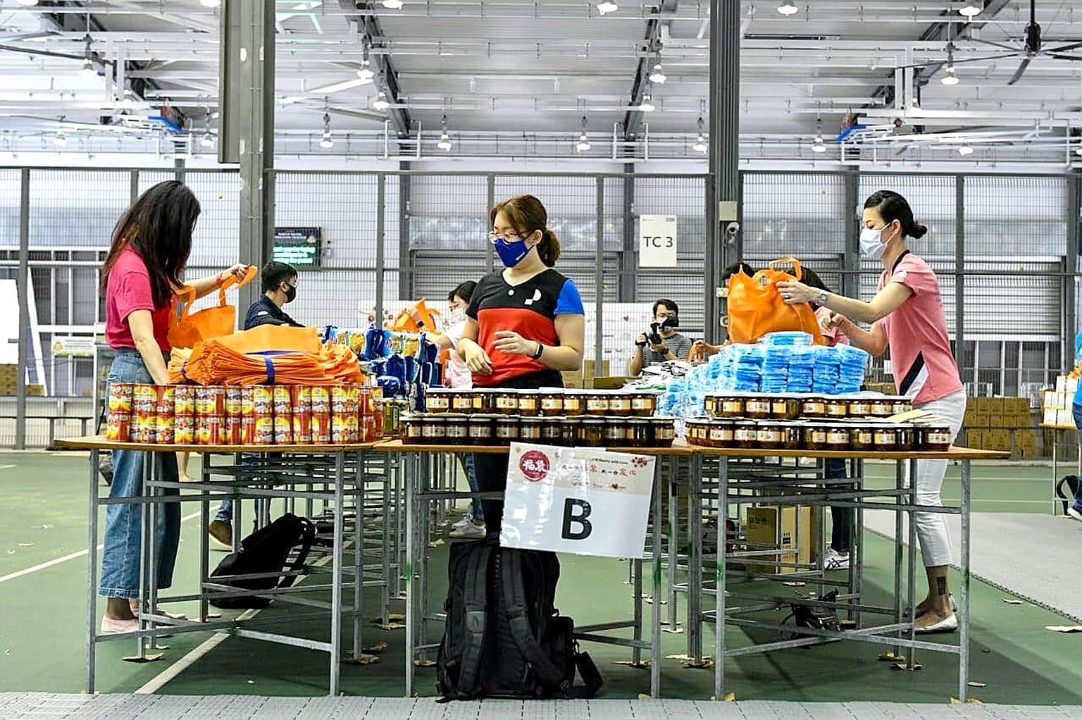 Volunteers packing the festive goodie bags at the Arena@Our Tampines Hub last week. The Community Chest will distribute the bags, containing various essential household and food items, to mark Chinese New Year this month. This is the eighth year that