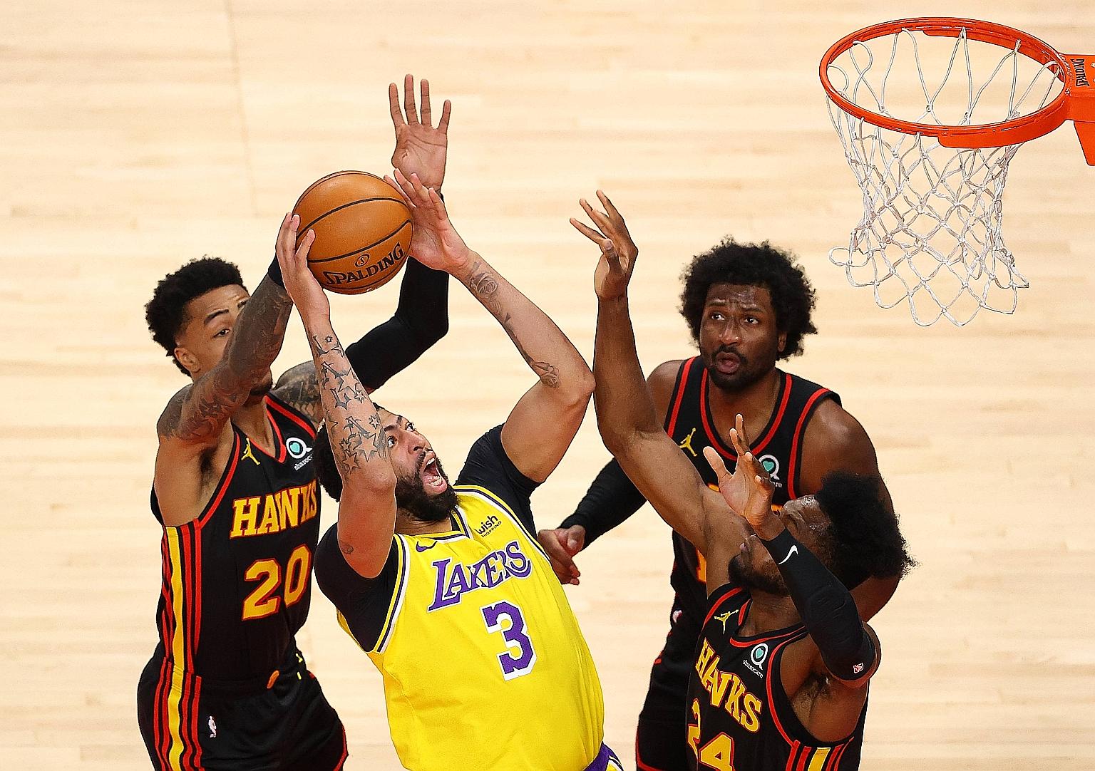 The Lakers' Anthony Davis drawing a foul from the Hawks' John Collins (far left) in their NBA game in Atlanta on Monday. The Lakers won 107-99 to end a seven-game road trip with five wins.