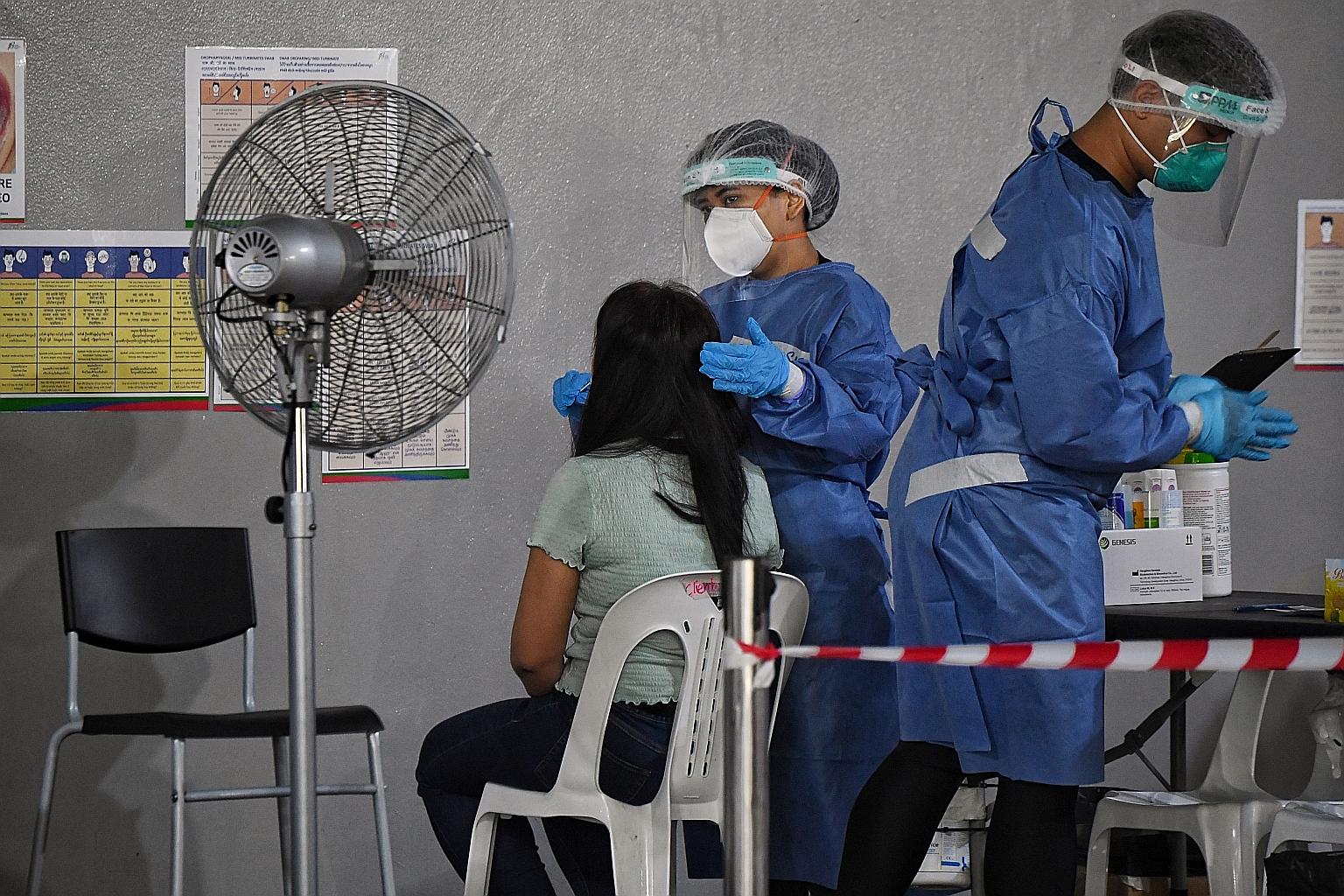 A woman getting tested for Covid-19 on Thursday. A 56-year-old import officer at Changi Airport was diagnosed with coronavirus after going for tuberculosis screening because he had come into contact with a TB patient at work.