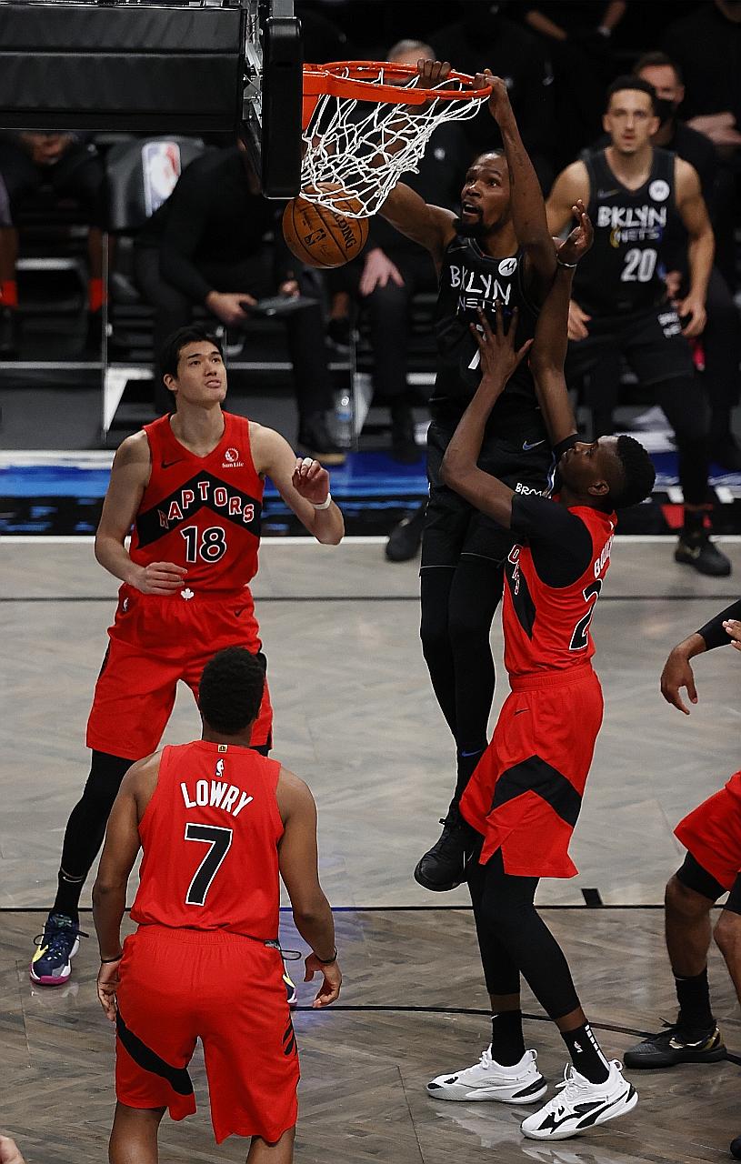 Brooklyn Nets' Kevin Durant dunking over Toronto Raptors' Yuta Watanabe and Chris Boucher in their NBA match on Friday. In his 19 minutes on court, Durant contributed eight points in the Nets' 123-117 loss. PHOTO: EPA-EFE