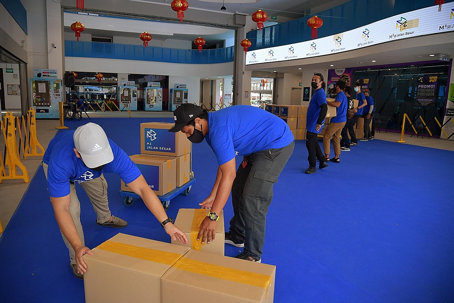 Volunteers moving care packs, which were distributed to about 150 families living in one-room rental flats in Geylang Bahru Road, yesterday.