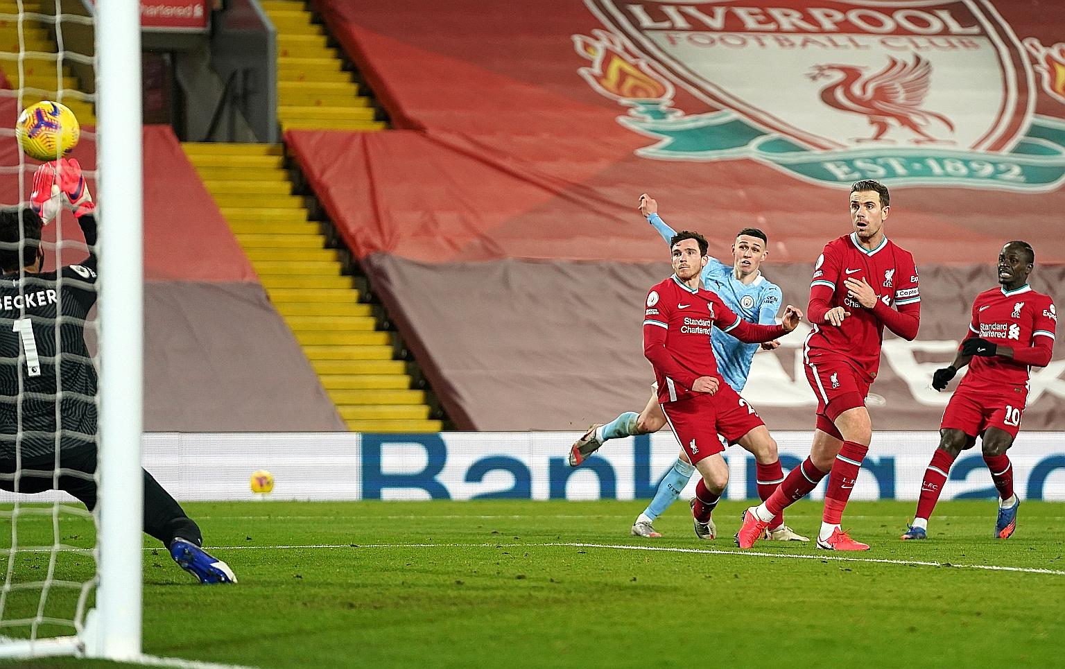 Manchester City's Phil Foden (in blue) scoring the fourth goal for his team against Liverpool on Sunday. The visitors' 4-1 victory ended their 18-year winless run at Anfield.
