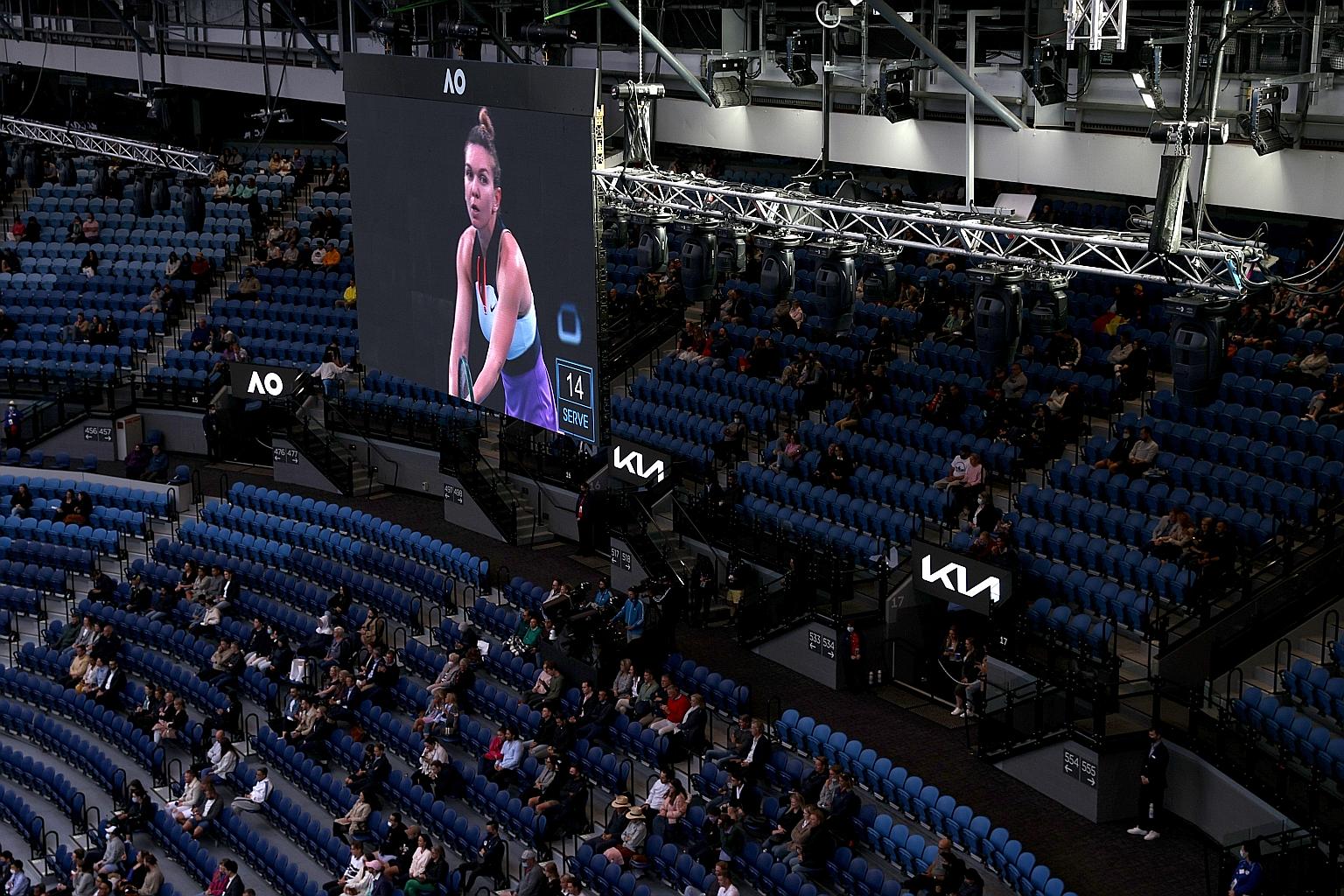 Distanced fans watching the first-round match between Romania's Simona Halep and Australia's Lizette Cabrera at the Australian Open. Only 17,922 fans turned out yesterday, just over half of the 30,000 daily limit for this year's event.