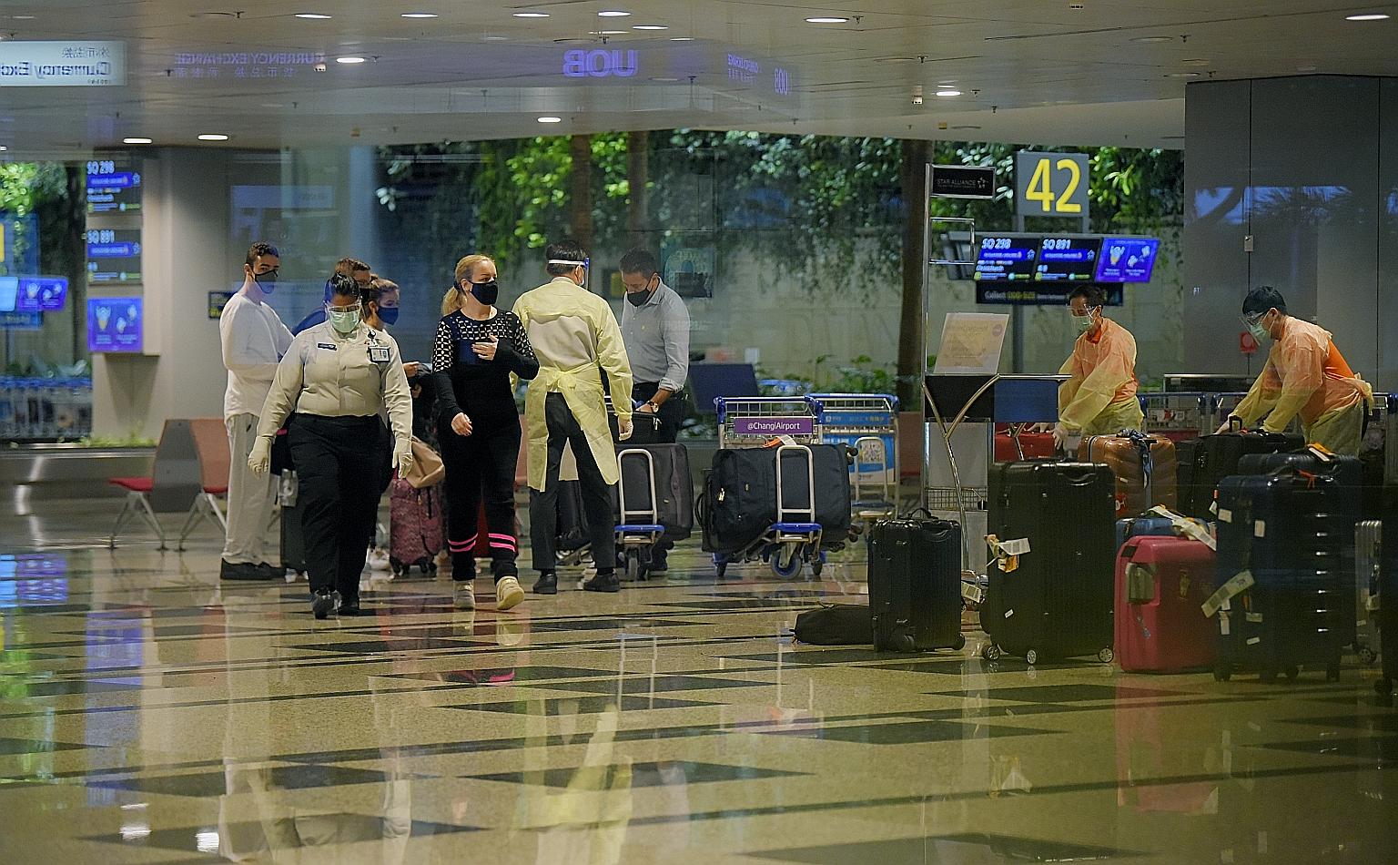 Passengers arriving at Changi Airport yesterday. The Immigration and Checkpoints Authority said traveller volume fell as demand for air travel came to a halt, with many countries imposing strict border control measures due to the Covid-19 pandemic. J