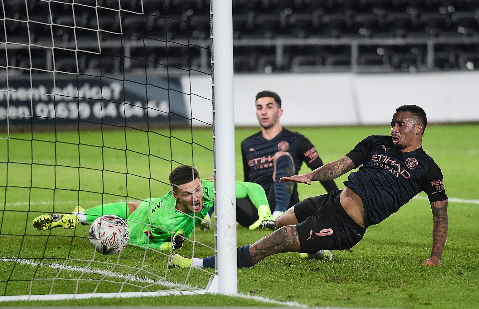 Swansea goalkeeper Freddie Woodman and Manchester City's Gabriel Jesus (right) watching the ball cross the goal line on Wednesday. The goal was scored by Kyle Walker, who is not in the frame.