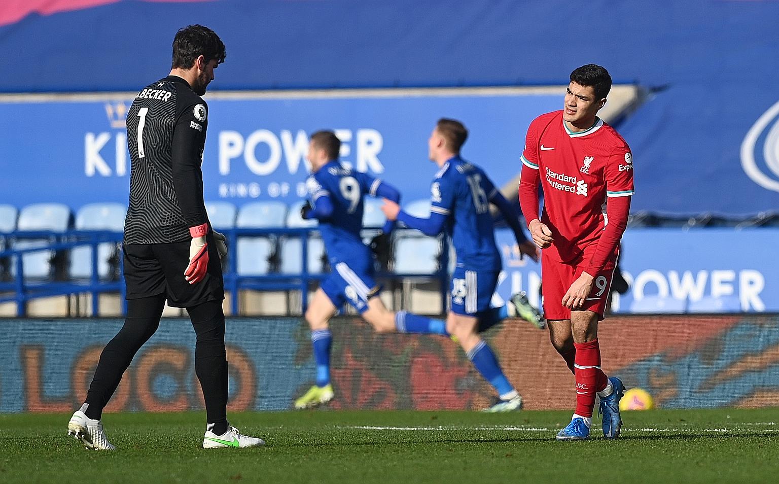 Liverpool's goalkeeper Alisson and defender Ozan Kabak look dejected after Leicester's Jamie Vardy scores their second goal to give the hosts the lead.
