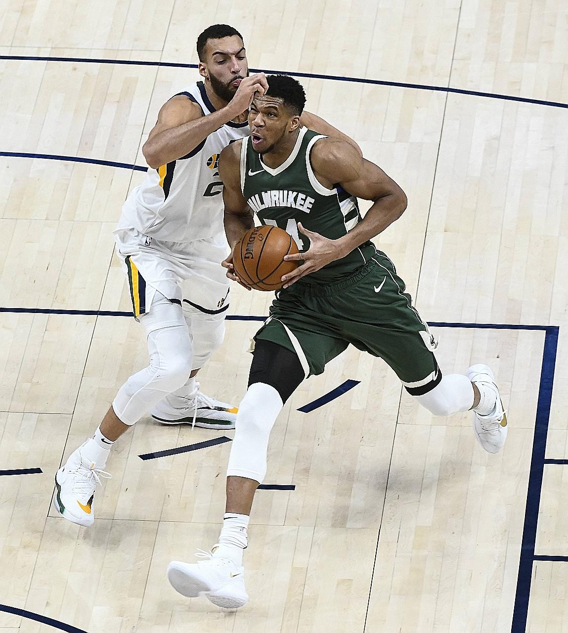 The Milwaukee Bucks' Giannis Antetokounmpo driving past the Utah Jazz's Rudy Gobert on Friday. The 2.11m Greek had 29 points, 15 rebounds and six assists. PHOTO: AGENCE FRANCE-PRESSE