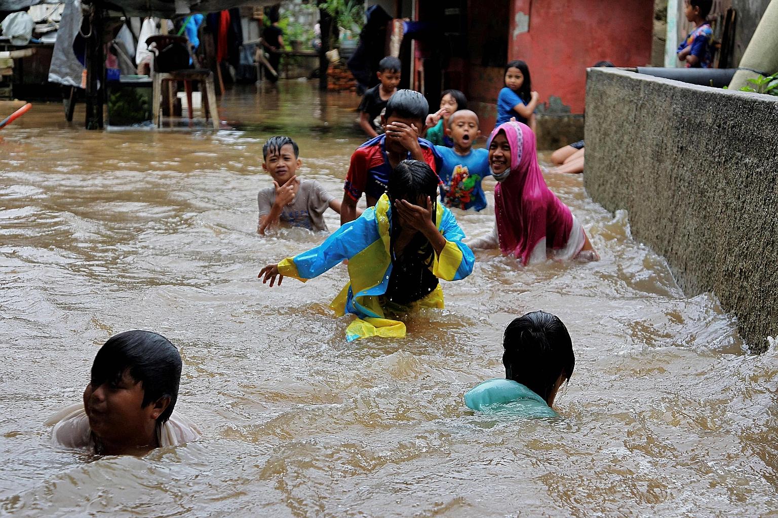 Children playing in flood waters outside their home in Jakarta yesterday, after heavy rain inundated parts of the Indonesian capital. The country has experienced at least 66 natural disasters, including quakes, floods and tornadoes, from early last m
