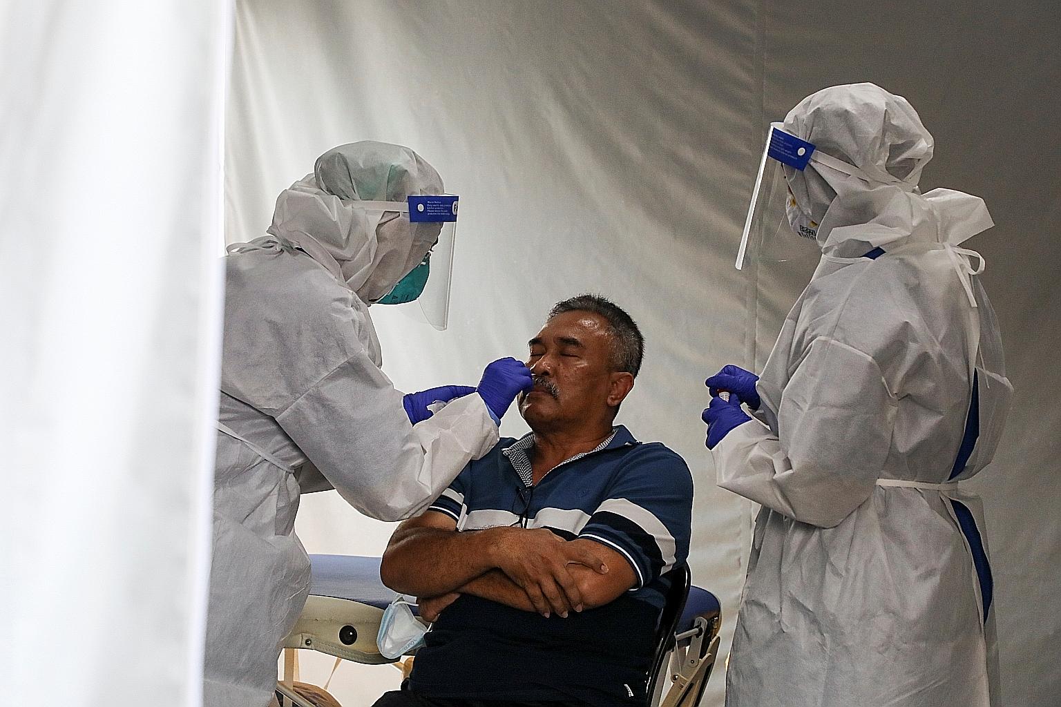 A man being tested for Covid-19 at the Kuala Lumpur Hospital yesterday. Malaysia recorded 2,176 cases on Monday, the lowest daily case tally since Jan 11.