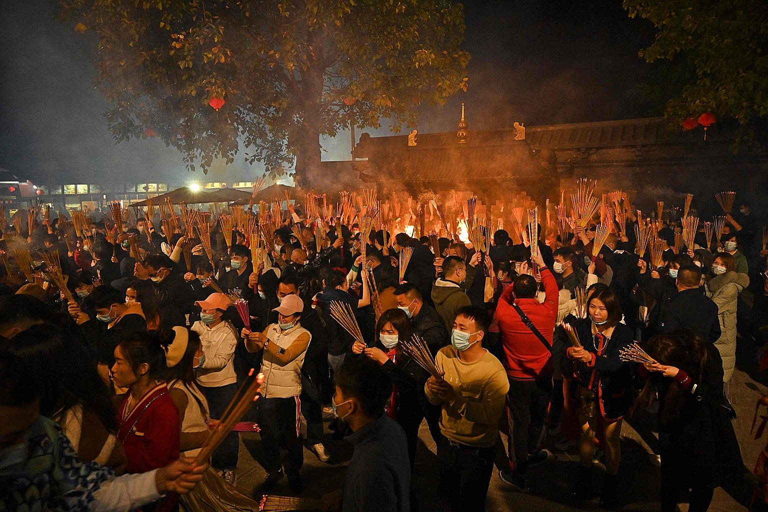 People praying for good luck on Chinese New Year's Eve at a temple in Nanning, the capital of China's southern Guangxi region. Researchers have pointed out that China is growing old before getting rich, a scenario that experts say limits a government