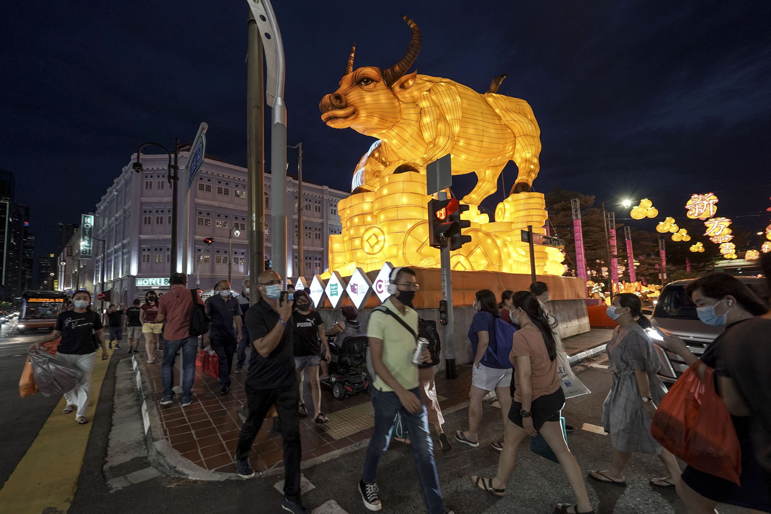 Pedestrians in Chinatown amid festive street decorations on Feb 8. Tighter measures introduced ahead of Chinese New Year include a cap of eight visitors per day per household. People were also reminded to wear masks at all times outside the home, inc