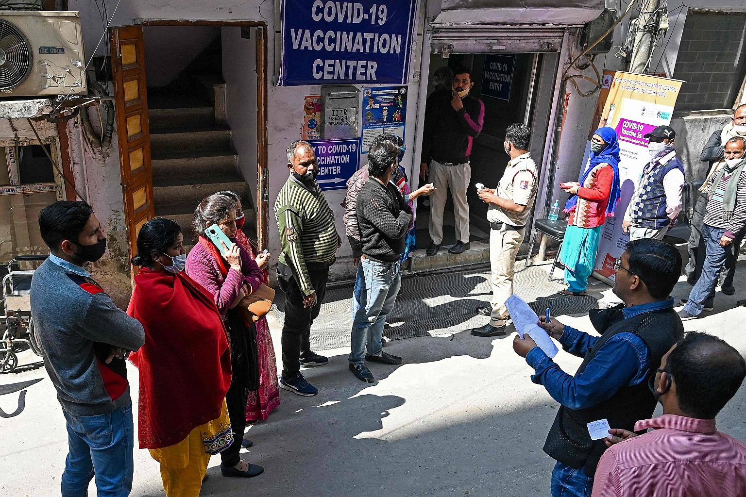 Municipal Corporation staff queueing for the vaccine in New Delhi yesterday. At current vaccination rates, India could overshoot its July to August target to inoculate 300 million people by several months.