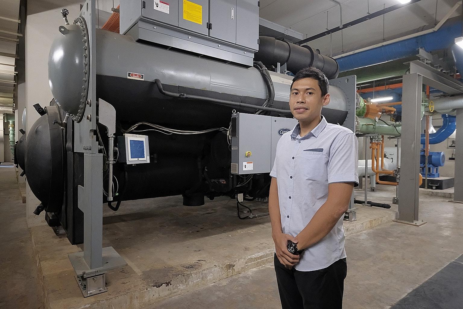 Mr Zulfadhli Fahim Suratman, a building and infrastructure specialist from the Home Team Science & Technology Agency, with the eco-friendly chillers behind him at a Home Team Academy building in Old Choa Chu Kang Road yesterday. ST PHOTO: GAVIN FOO