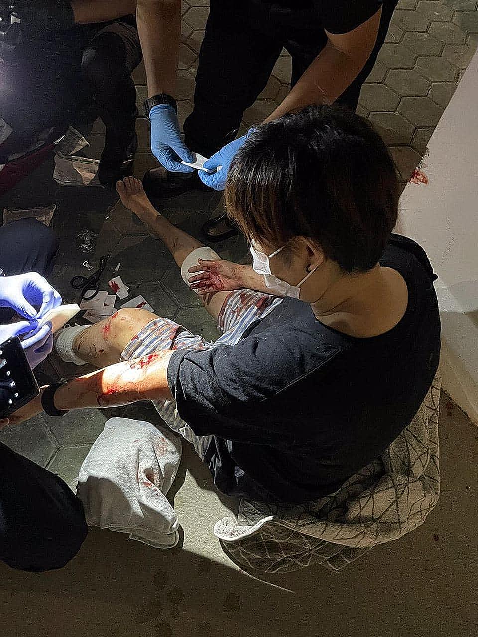 Paramedics attending to a woman who was bitten by a wild boar in Punggol Walk last Saturday night. Another person was attacked shortly after, it is believed, by the same animal. PHOTO: LIANHE ZAOBAO READER