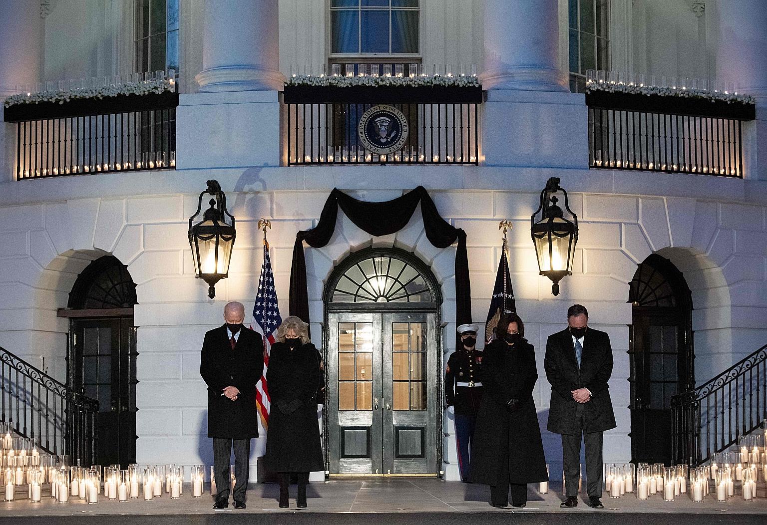 US President Joe Biden and First Lady Jill Biden, along with Vice-President Kamala Harris and her husband Doug Emhoff, observing a moment of silence during a candlelight ceremony at the White House on Monday in honour of those who lost their lives to