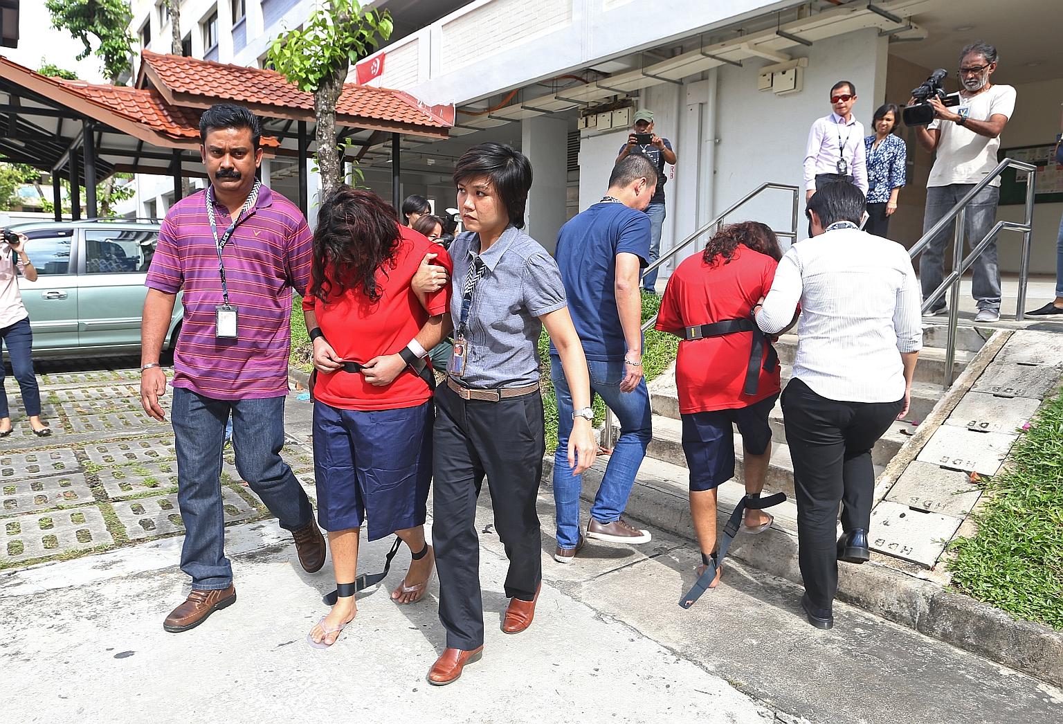 Police officers taking Gaiyathiri Murugayan (left, in red) and her mother Prema S. Naraynasamy (right, in red) to their home in Bishan for investigations on Aug 3, 2016.