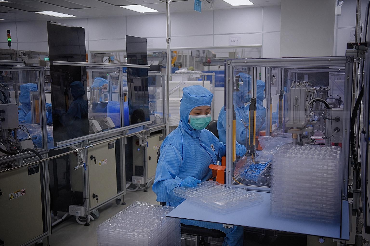 Workers at local engineering firm Univac Precision Engineering. Production in Singapore's precision engineering cluster climbed 15.3 per cent last month, thanks to higher output in the machinery and systems segment, which surged 20.2 per cent due to