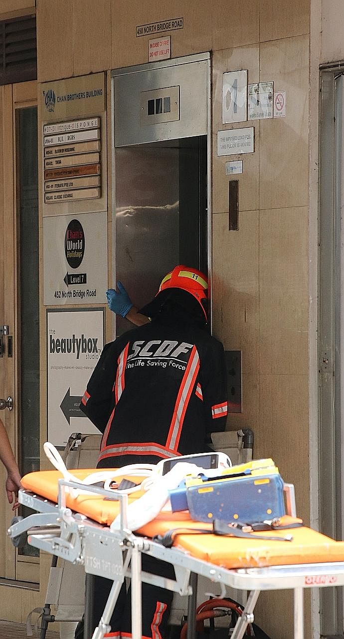 Above: The building at 450 North Bridge Road, where the worker was trapped in the lift shaft. Left: Extricating him took about six hours, in what SCDF said was a highly complex and delicate operation. Below: Police officers at the scene yesterday. PH