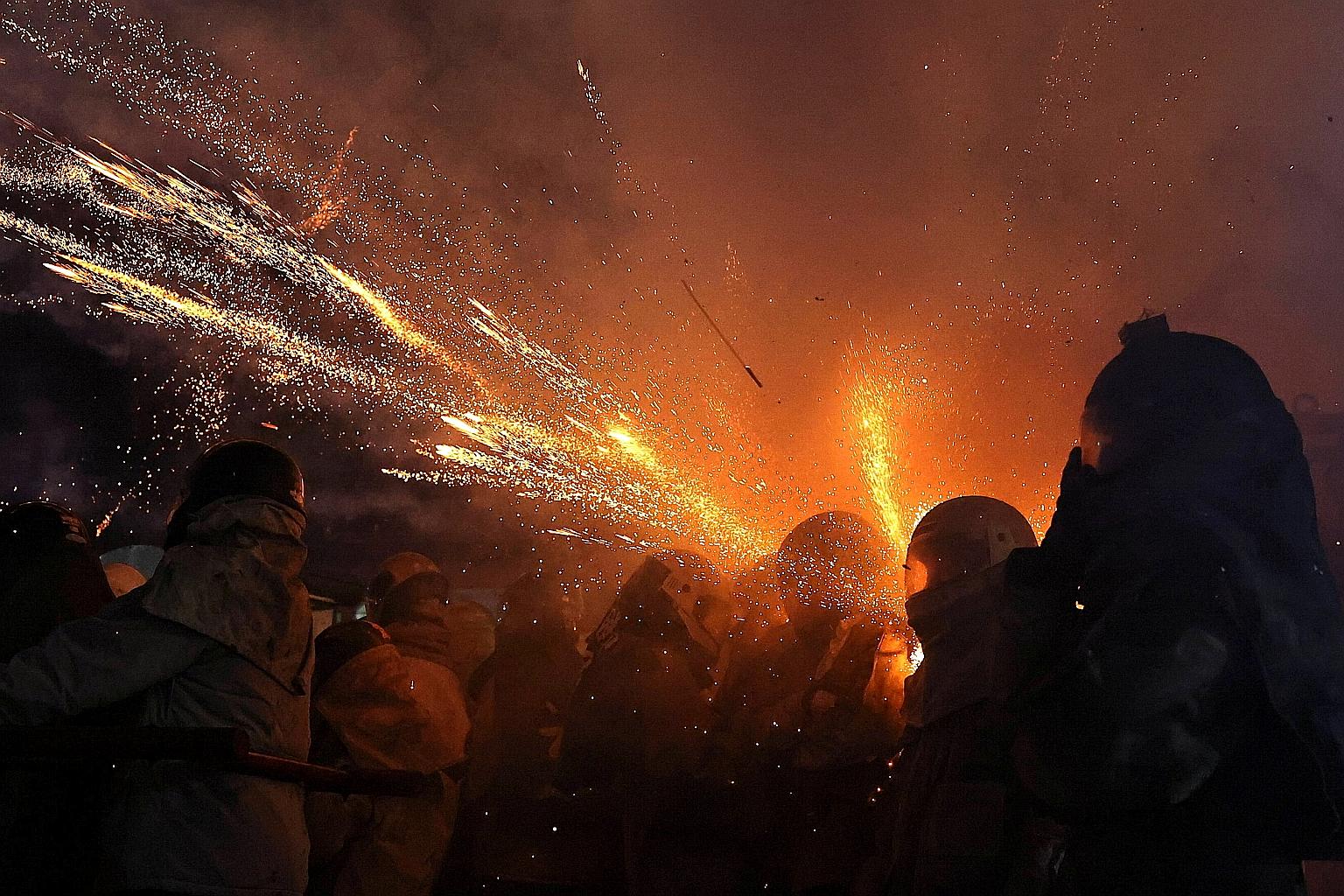 Participants wearing motorcycle helmets and thick coats to avoid injury as firecrackers go off at the Beehive Fireworks Festival in Yanshui, Tainan, on Friday. PHOTO: REUTERS