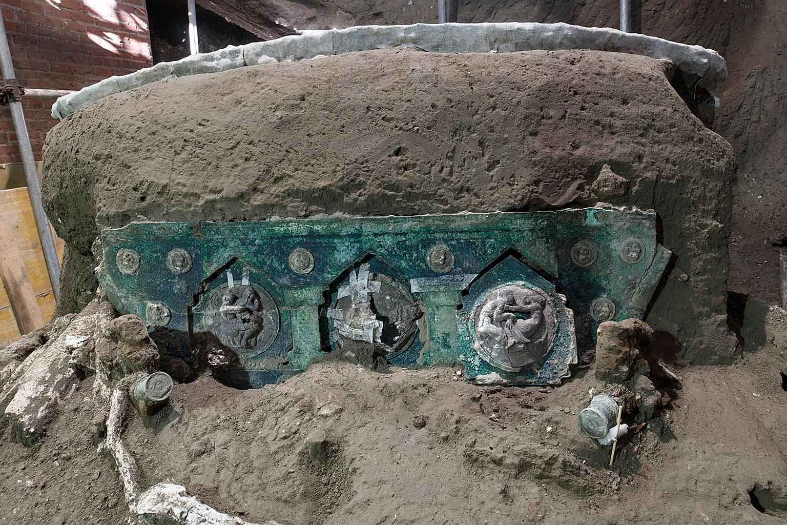 Above and left: The four-wheeled processional carriage was found near where the remains of three horses were unearthed in 2018. The carriage was found almost intact, along with its iron components, bronze and tin decorations, and mineralised wood rem