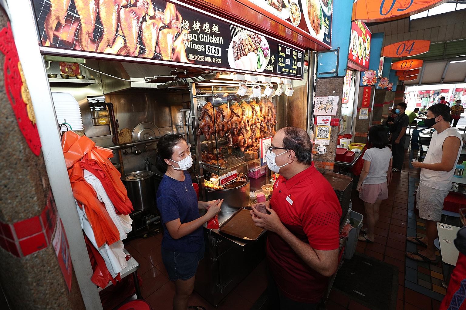 Mr S. Iswaran, Minister for Communications and Information, meeting a stallholder at Ayer Rajah Market and Food Centre earlier this month. In an interview with ST, he noted that more hawkers are taking part in the Hawkers Go Digital scheme, with 10,0